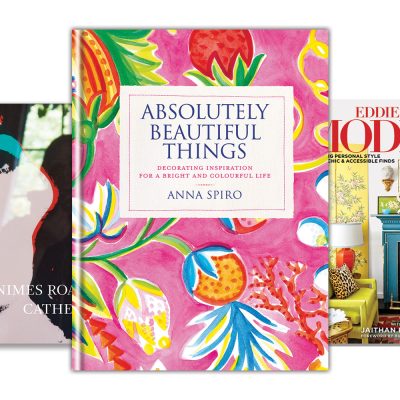 Three interior design books arranged in a stack, featuring 'Absolutely Beautiful Things' by Anna Spiro with a bright pink floral cover, '700 Nimes Road' by Catherine Opie with a pop-art style portrait, and 'Eddie Ross Modern Mix' highlighting a colorful room.