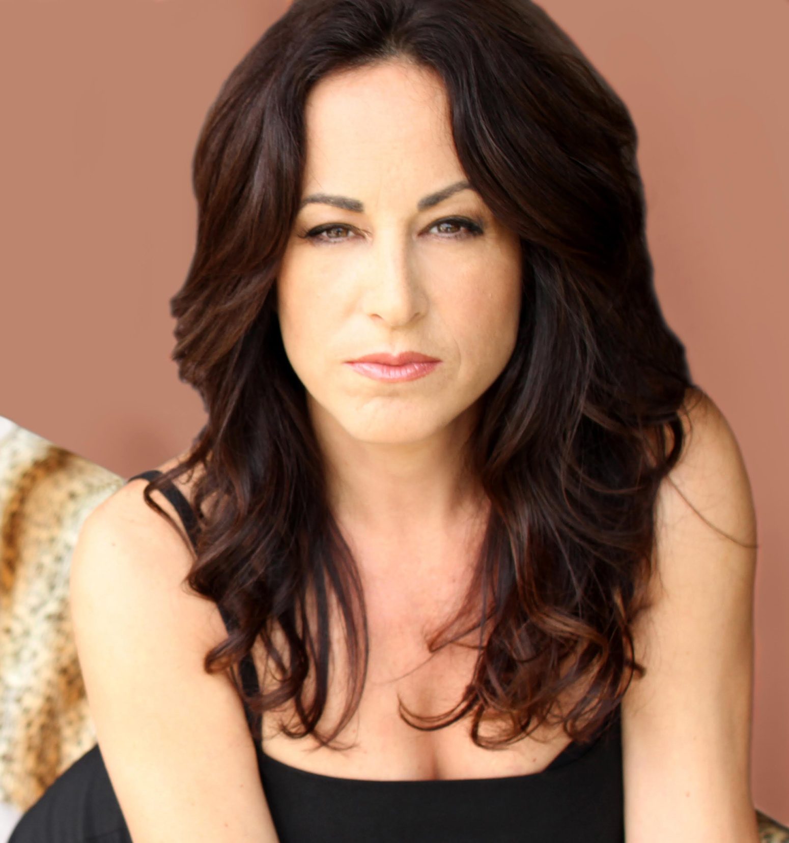Close-up portrait of interior designer Christina Karras with long dark wavy hair, wearing a black top, looking directly at the viewer. This image introduces the subject of the article.